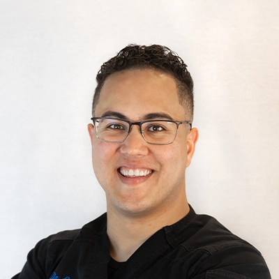 Chiropractor Eric Rivera Smiling In Front Of White Background