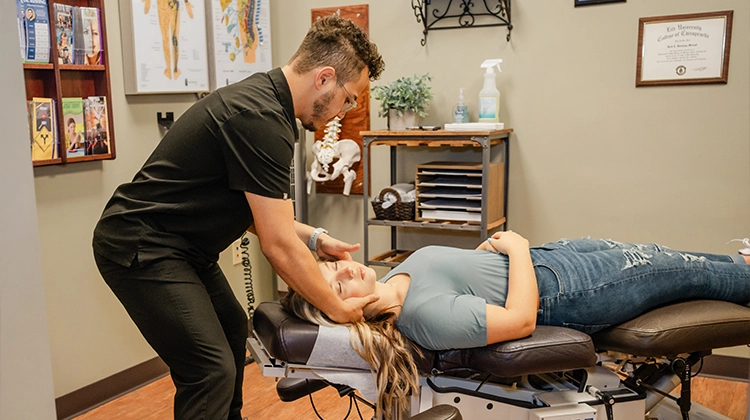 Chiropractor Eric Rivera Adjusting A Patients Neck