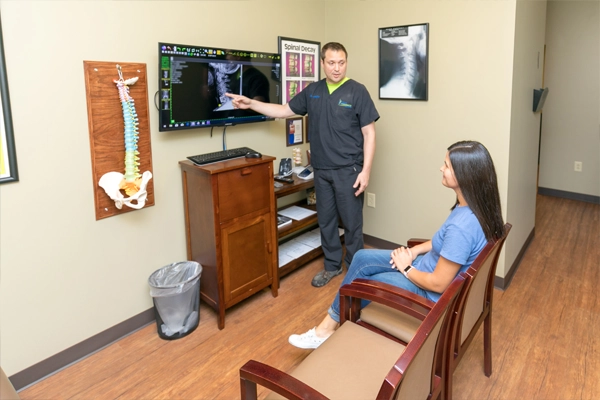 Chiropractor Ringgold GA Jason McRae Pointing To XRay With Patient Chiropractor Jason McRae Pointing To XRay With Patient At Pray Chiropractic - Ringgold