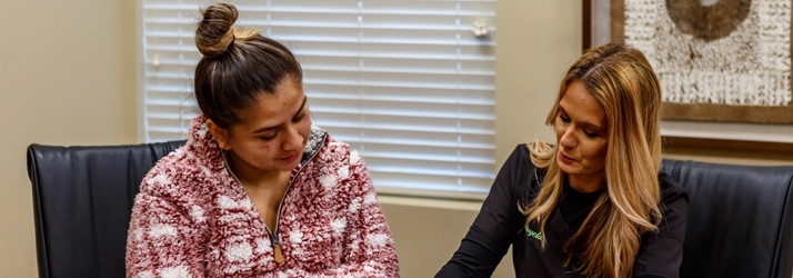 Staff Member Helping Patient With Their Paperwork