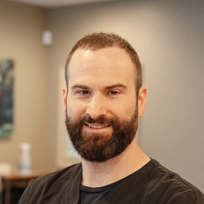 Chiropractor James Bodkin Smiling In Front Of Blurred Background